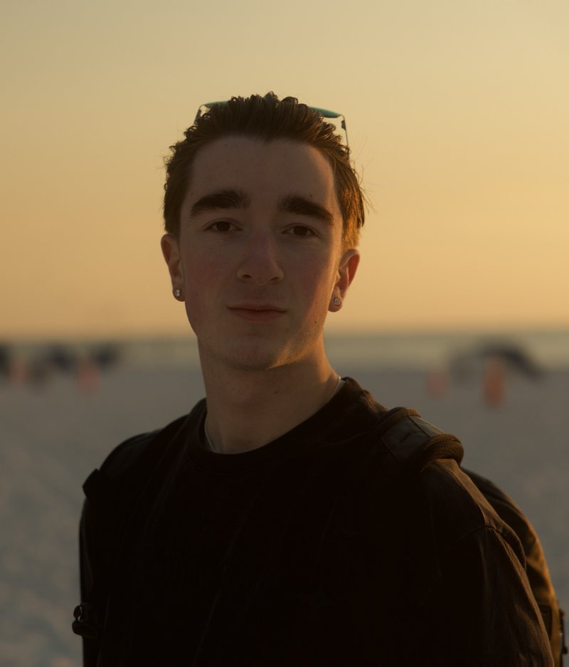 Liam Rieber at golden hour, sunglasses pushed up, half a smile